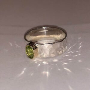 Silver hammered ring with fresh green peridot gemstone with 9ct gold setting